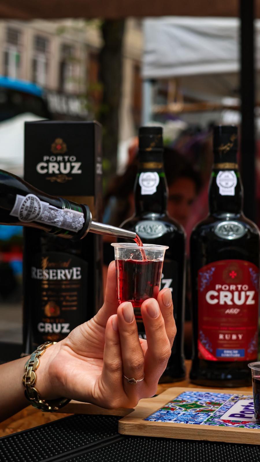 Vinho do Porto a ser servido num copo de shot num evento ao ar livre
