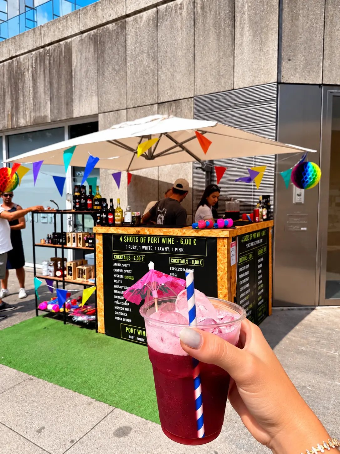 Cliente com um cocktail HENTZ à frente de um bar ao ar livre