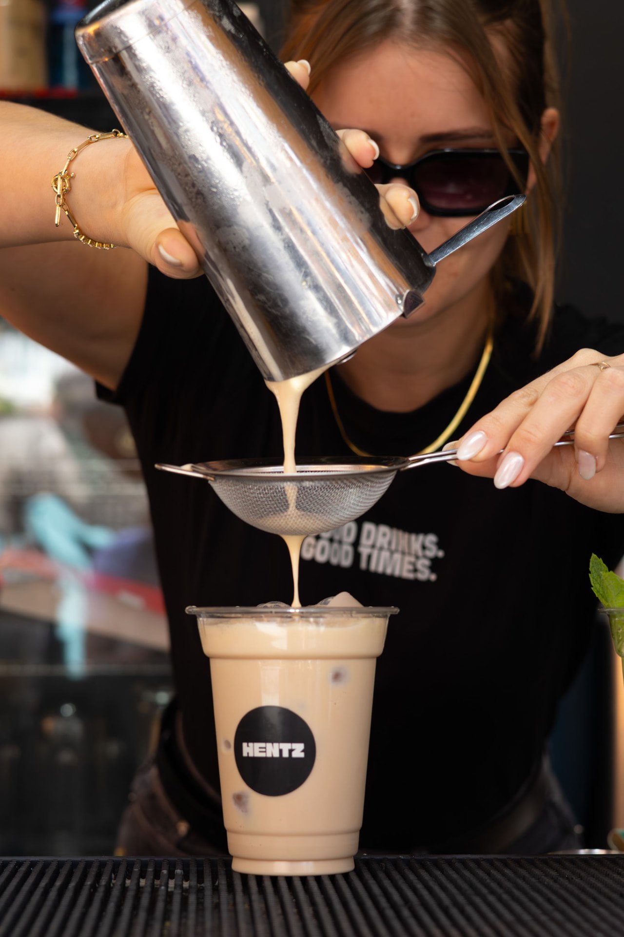 Barman HENTZ a coar um cocktail cremoso para um copo HENTZ