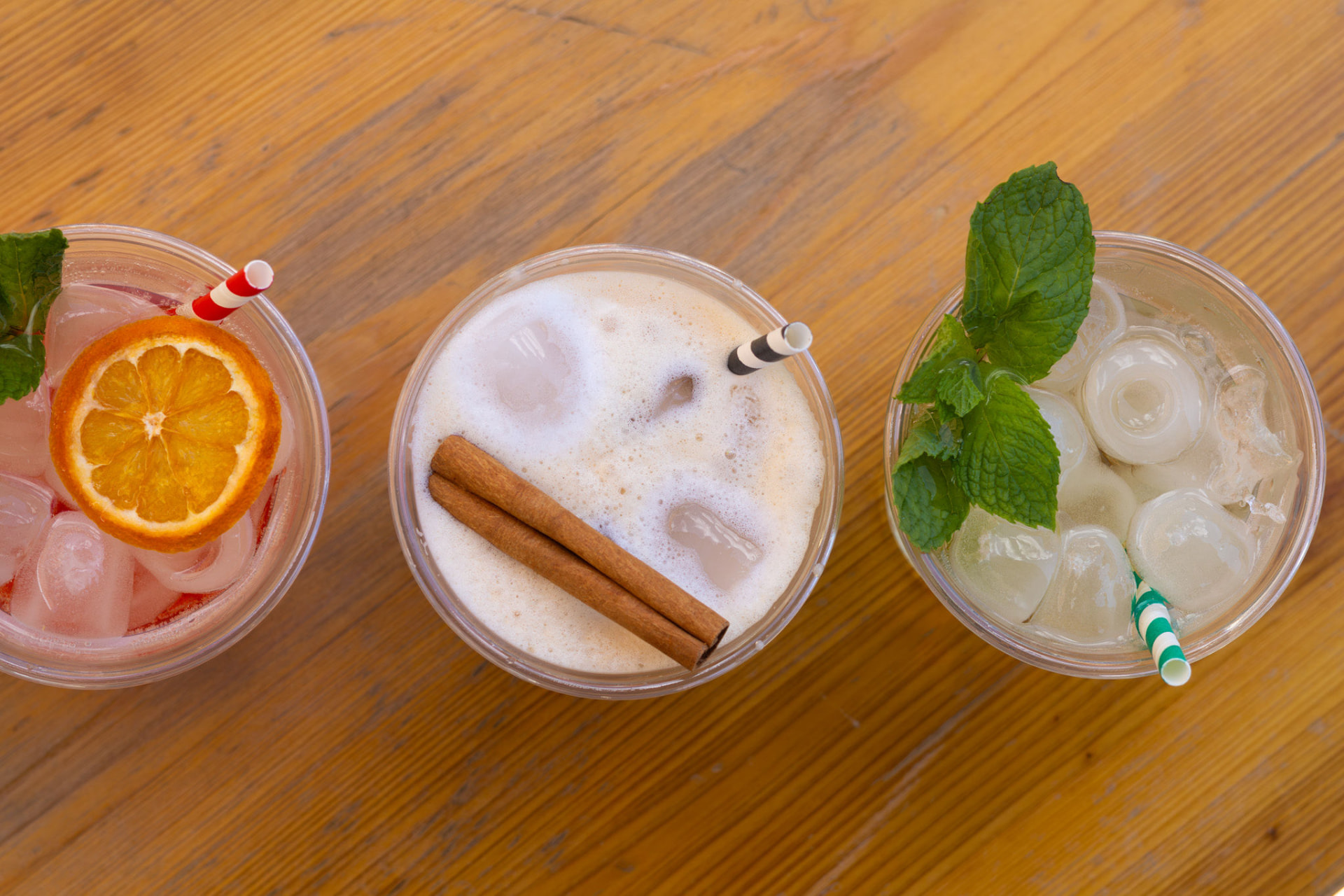 Três cocktails HENTZ servidos em copos sobre uma mesa de madeira